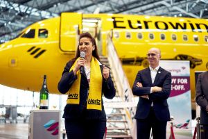 Gelbes Flugzeug von Eurowings fliegt mit Hertz